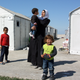 A family outside their homes in Diavata camp.